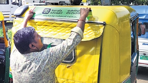 An autorickshaw driver in Kochi gets ready to operate under the digital platform ‘kerala savaari’.