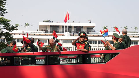 Vietnam War veterans on an open bus pass the Independence Palace during a parade to commemorate the 50th anniversary of the end of the Vietnam War in Ho Chi Minh City Wednesday, April 30, 2025.