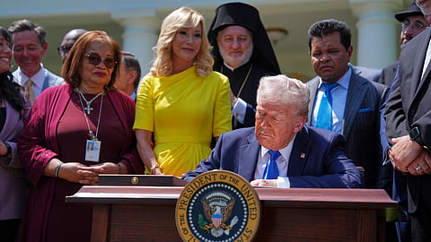 President Donald Trump, surrounded by religious leaders, signs an executive order establishing the Religious Liberty Commission, during a National Day of Prayer event in the Rose Garden of the White House, Thursday, May 1, 2025, in Washington.