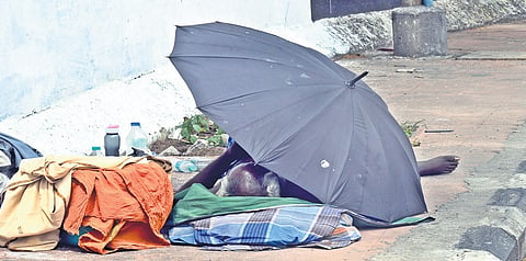 An elderly homeless person resting on a footpath at Royapuram in Chennai