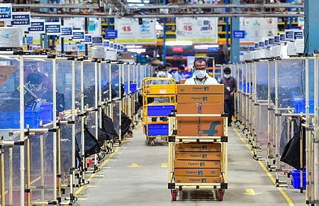 Employees carry the products for shipment from packaging area at a fulfilment centre of E-commerce firm Flipkart.