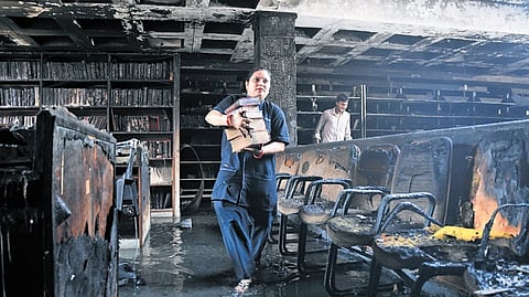 Books being removed after a fire broke out in the library of Guru Gobind Singh College of Commerce, in northwest Delhi's Pitampura, Thursday, May 15, 2025.