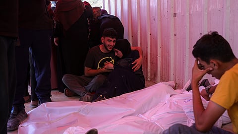 People mourn over the shrouded bodies of victims of Israeli strikes on Jabalia, at the Indonesian hospital in Beit Lahia, in the northern Gaza Strip, on May 15, 2025.