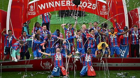 Marc Guehi and Joel Ward of Crystal Palace lift the FA Cup trophy after their team’s victory in the Emirates FA Cup Final match between Crystal Palace and Manchester City at Wembley Stadium on May 17, 2025 in London, England.