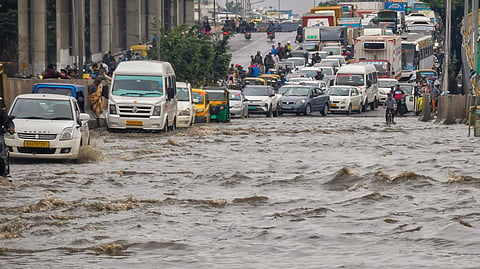 Vehicles wade through a waterlogged road after heavy rains, in Bengaluru, Tuesday, May 20, 2025.