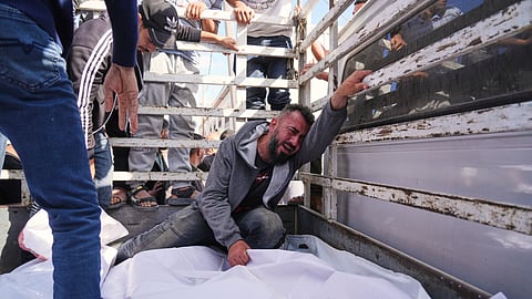 Osama Abu Mosabbah, mourns his wife and two children who were killed in an Israeli army airstrike on the Gaza Strip, during their funeral at Al-Aqsa Hospital in Deir al-Balah, Gaza, Tuesday, May 20, 2025.