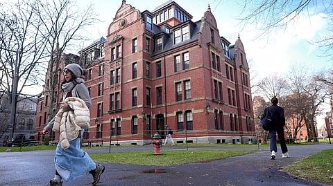 People walk between buildings, Dec. 17, 2024, on the campus of Harvard University in Cambridge, Mass.