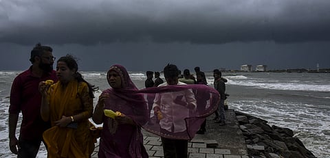 Visitors at beach during rainfall with strong winds, in Kochi, Kerala, Sunday, May 25, 2025.