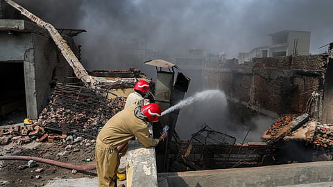 Firefighters try to douse a fire that broke out at a factory, at Bawana industrial area, in New Delhi, Saturday, May 24, 2025. The fire triggered an explosion, causing the building to collapse