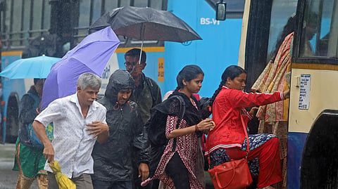 eople witness the morning rain shower as they leave for their work on Kengeri ring road in Bengaluru on Monday.