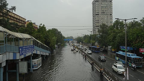 Commuters wade through a waterlogged road following rains, at ITO in New Delhi, Sunday, May 25, 2025.