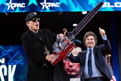 Elon Musk holds up a chainsaw he received from Argentina's President Javier Milei, right, as they arrive to speak at the Conservative Political Action Conference, CPAC, at the Gaylord National Resort & Convention Center, Feb. 20, 2025, in Oxon Hill, Md.