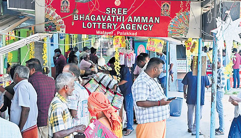 A busy lottery stall at Walayar. (Below) Customers purchasing lottery tickets.