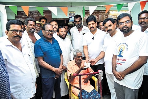 Excise minister Kollu Ravindra handovers pension to the beneficiary on Saturday.