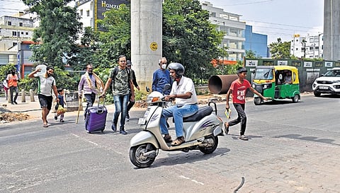 Pedestrians struggle to cross as motorists ignore traffic rules near Babusapalya Metro construction site in Bengaluru, on Sunday.