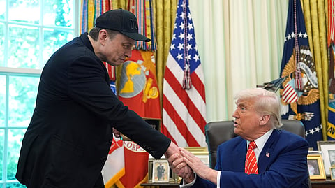 US President Donald Trump, right, shakes the hand of Elon Musk.