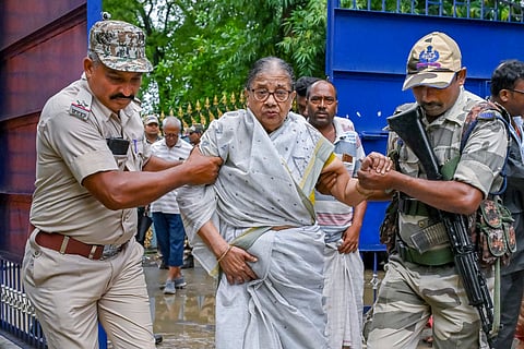 Paramilitary forces personnel assist a voter at a polling station during the by-election to the Kaliganj assembly seat, in Nadia district, Thursday, June 19, 2025.
