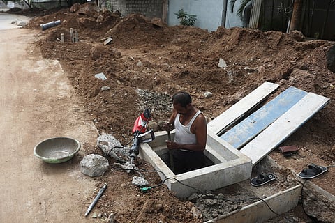 A GHMC worker is busy constructing drainage pits to ensure smooth rainwater flow
