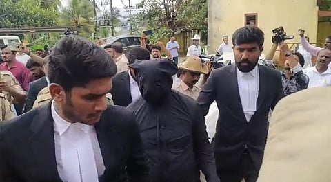 The complainant was granted witness protection as per his request. Here, he is seen clad in black clothing to hide his identity.