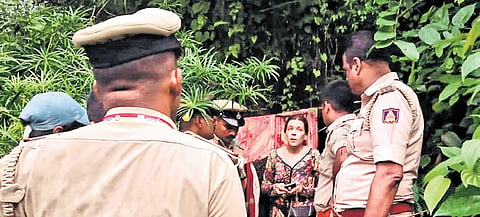 Police personnel confront Russian woman Nina Kutina, who lived with her children in a cave in Gokarna