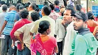 People queue in front of the SCB diagnostic centre under the open sky