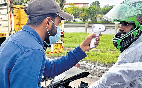 Passengers from Kerala being checked by Tamil Nadu health authorities at the state border on Wednesday