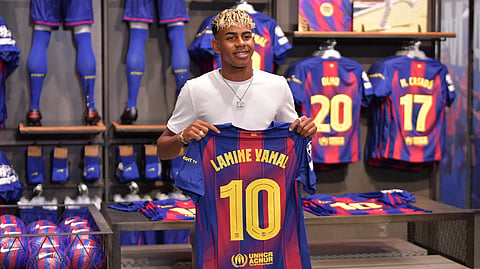 Barcelona's Spanish forward Lamine Yamal poses holding his new #10 jersey at the Camp Nou stadium's shop on July 16, 2025 in Barcelona.