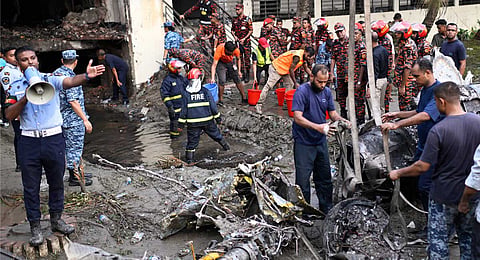 Firemen work at the site of a Bangladesh Air Force training aircraft that crashed into a school campus shortly after takeoff in Dhaka, Bangladesh, Monday, July 21, 2025.