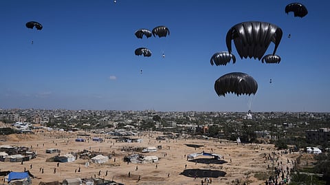 Palestinians rush to collect humanitarian aid airdropped by parachutes into Zawaida in the central Gaza Strip, Thursday, July 31, 2025.