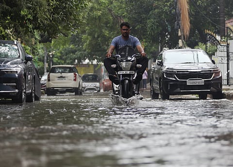 Commuters wading through a waterlogged road following the rains in Hyderabad.