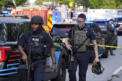 Armed police officers walk near the scene of shooting at the Emory University in Atlanta on Friday, Aug. 8, 2025.