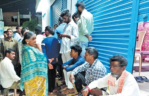 Farmers and their family members wait for urea at a fertiliser shop in Rudrangi, Rajanna-Sircilla district, on Friday night.