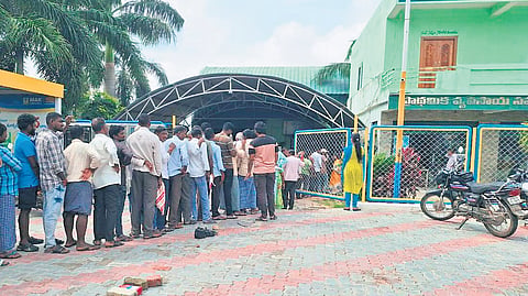 Farmers stand in a queue at Illanthakunta mandal in Rajanna-Sircilla district on Monday