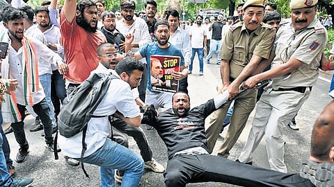 Delhi police detain a protester during IYC's protest in New Delhi on Tuesday.