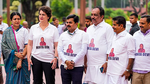 Congress MP Priyanka Gandhi Vadra and other INDIA bloc members seen wearing T-shirts featuring the name Minta Devi, a voter allegedly listed as 124 years old in the Election Commission's voter list, during their protest over the issues of 'poll fraud' and Special Intensive Revision of electoral rolls, at the Monsoon session of Parliament, in New Delhi, Tuesday, Aug. 12, 2025.