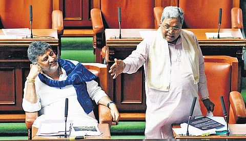 Chief Minister Siddaramaiah speaks as Deputy Chief Minister DK Shivakumar looks, during the Assembly session at Vidhana Soudha in Bengaluru on Friday