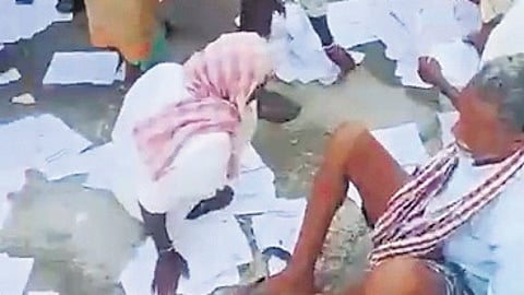 Farmers throw photocopies of their passbooks and Aadhaar cards at the Maripeda PACS in Mahbubabad district.