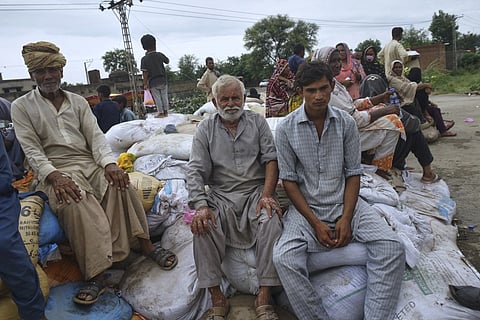 Villagers shelter after being evacuated from a floods following torrential rains and rising rivers due to sudden water releases from Indian dams in Pindi Bhattian, Pakistan, Sunday, Aug. 31, 2025.