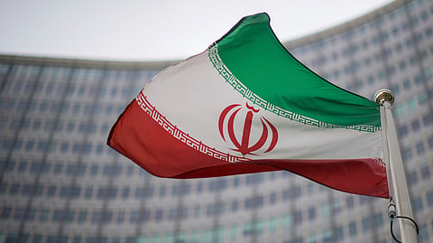 FILE - A national flag of Iran waves in front of the building of the International Atomic Energy Agency, IAEA, in Vienna, Austria, Friday, Dec. 17, 2021.