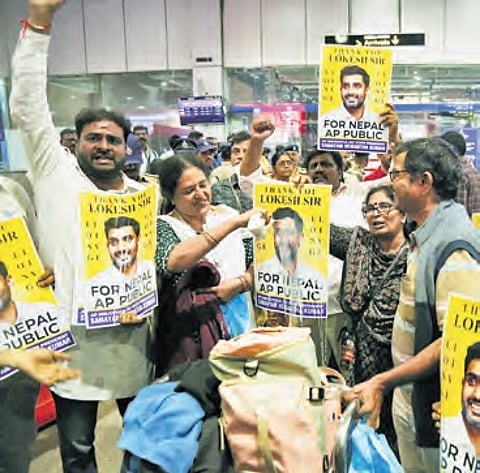 Telugu people, who returned from trouble-torn Nepal, perform ‘Ksheerabhishekam’ on the photo of IT Minister Nara Lokesh at the airport in Vizag.