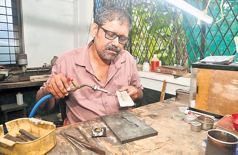 A traditional gold artisan working at his unit in Thrissur