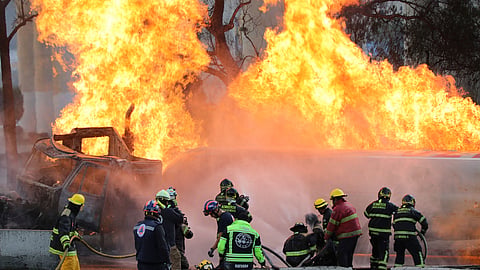 Firefighters spray hoses at a gas tanker that exploded under a highway overpass in Mexico City, Wednesday, Sept. 10, 2025.