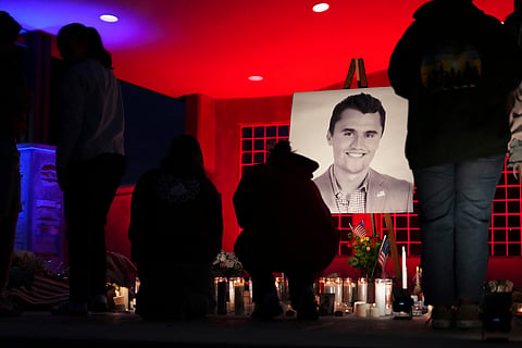 People place lit candles below a photo of Charlie Kirk, the CEO and co-founder of Turning Point USA who was shot and killed, at a vigil in his memory, Thursday, Sept. 11, 2025, in Orem, Utah.
