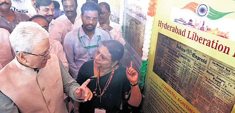 Governor Jishnu Dev Varma looks at a clipping of Indian Express displayed at the photo exhibition at Parade Grounds on Sunday.