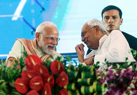 Prime Minister Narendra Modi and Bihar CM Nitish Kumar share a light moment during a public meeting in Purnea on Monday