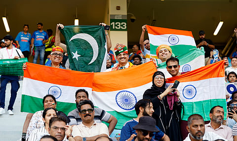 Indian and Pakistani fans holding their national flags pose for a picture before the start of the Asia Cup 2025 match between India and Pakistan at Dubai International Stadium in Dubai on Sept. 14, 2025.
