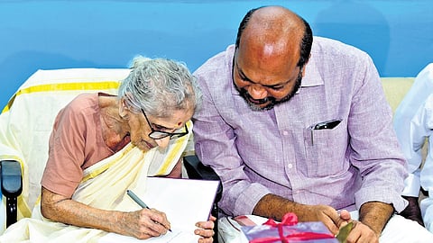M Leelavathi signs a copy of the book containing a collection of her selected works for Industries Minister P Rajeeve in Kochi.