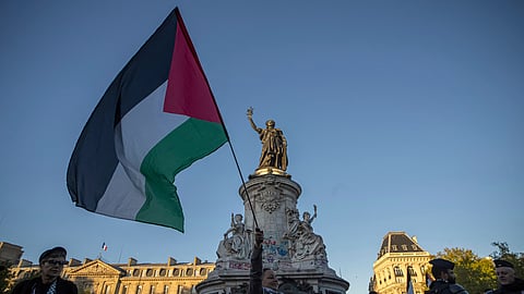 A woman holds a Palestinian flag during a pro-Palestinian gathering at Republic square in Paris, Wednesday, Sep. 17, 2025.