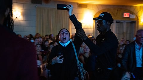 A pro-Palestinian protester is escorted out of former Vice President Kamala Harris' book launch event for her new book about her presidential campaign, "107 days," at Town Hall in New York, Wednesday, Sept 24, 2025