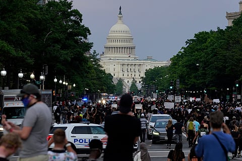 Demonstrators walk along Pennsylvania Avenue as they protest the death of George Floyd, May 29, 2020, in Washington.